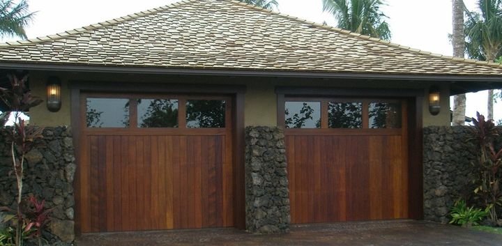 Timber entry doors set into a stone wall under a deep eave, Kukio Residence, Hawaii Island