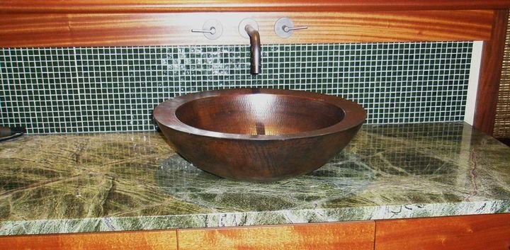 Hammered copper vessel sink set into a stone counter, North Shore Beach House, Oahu