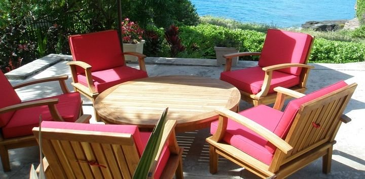 Teak outdoor lounge chairs with red cushions around a round table, Portlock Residence, Oahu