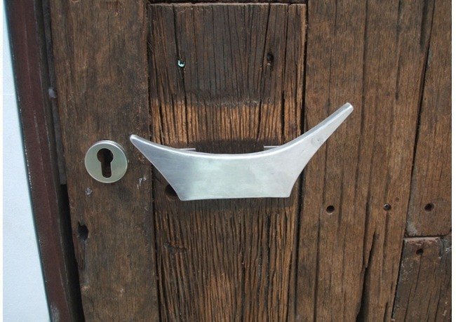 Cast metal door pull mounted on a weathered timber door, Toraja Villa, Bali