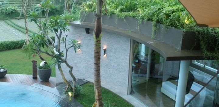 Villa and pool edged with planting and wall lanterns, Toraja Villa, Bali