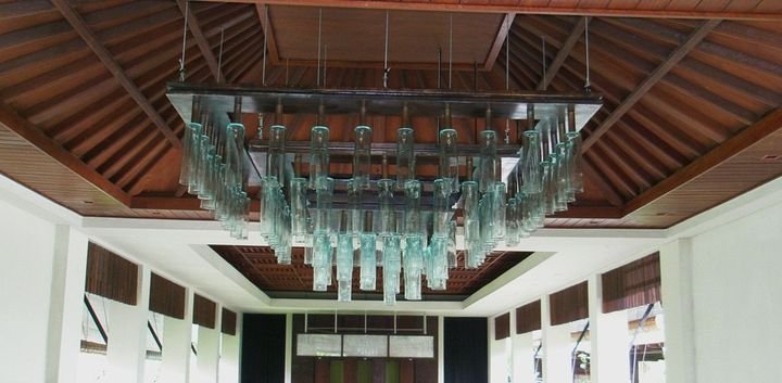 Suspended glass chandelier under an open timber roof, Vimala Resort, Bali